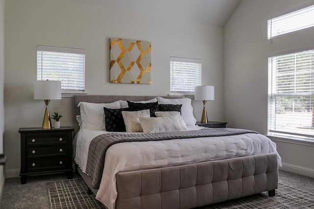 bedroom with dark carpet, vaulted ceiling, and baseboards
