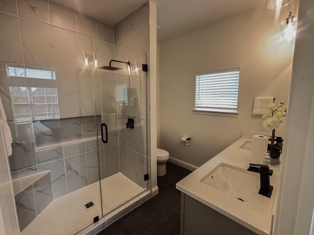 full bath with double vanity, toilet, a sink, baseboards, and a stall shower