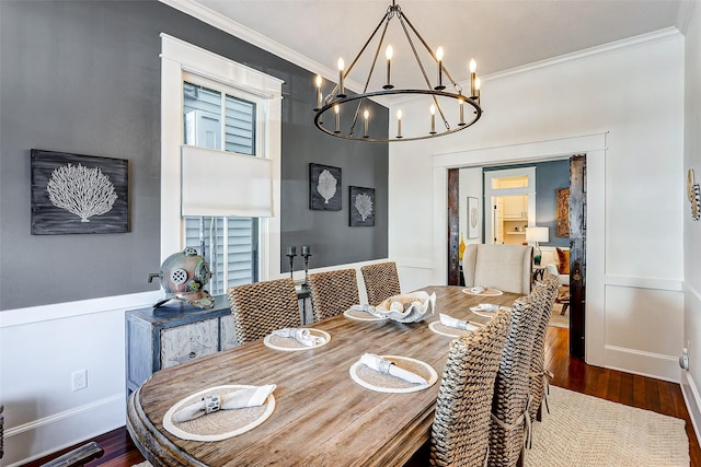 dining space featuring baseboards, dark wood-style flooring, a notable chandelier, and crown molding