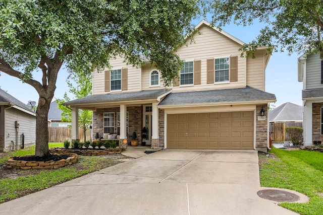 traditional-style house featuring fence, an attached garage, driveway, a porch, and stone siding