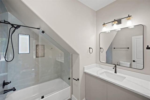 bathroom featuring vanity, toilet, and bath / shower combo with glass door