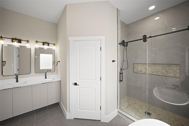 full bath with a shower stall, double vanity, tile patterned floors, and a sink