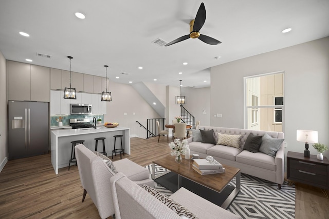 living area with recessed lighting, light wood-type flooring, visible vents, and a ceiling fan