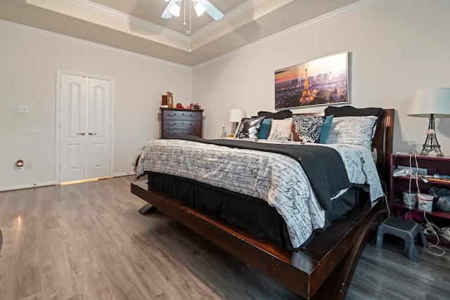 3203 Jeanette Cir, Mont Belvieu, TX 77523 - bedroom featuring wood finished floors, a tray ceiling, crown molding, a ceiling fan, and baseboards