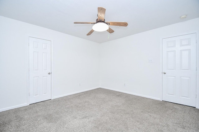 spare room featuring ceiling fan, baseboards, and carpet