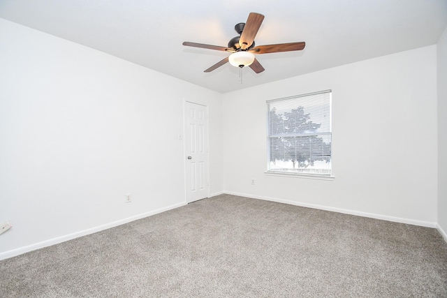 empty room featuring ceiling fan, baseboards, and carpet