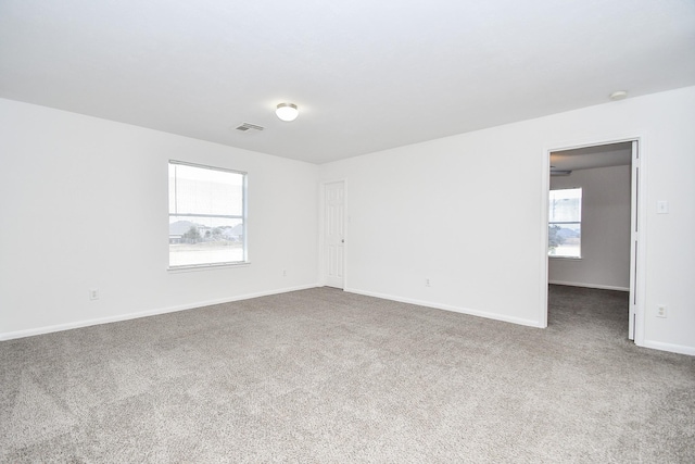 carpeted empty room with baseboards and visible vents
