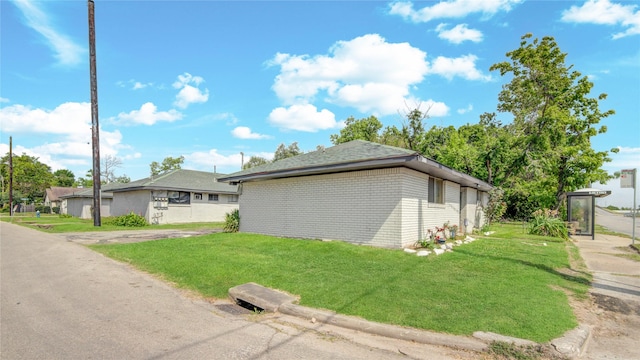 view of side of property with a lawn and brick siding