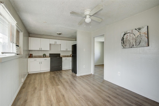 5409 Suez St Unit 4, Houston, TX 77020 - kitchen with white cabinets, light wood-style floors, a textured ceiling, and black appliances