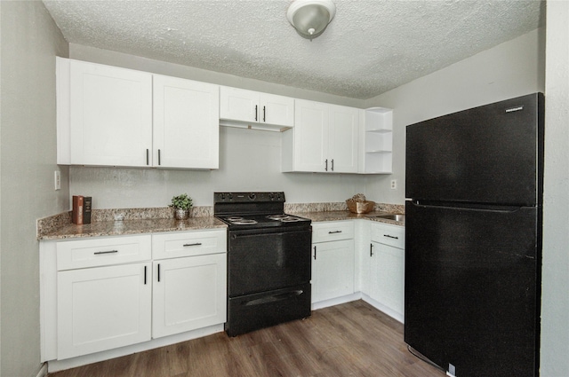 5409 Suez St Unit 4, Houston, TX 77020 - kitchen featuring light stone counters, open shelves, black appliances, white cabinets, and dark wood-type flooring