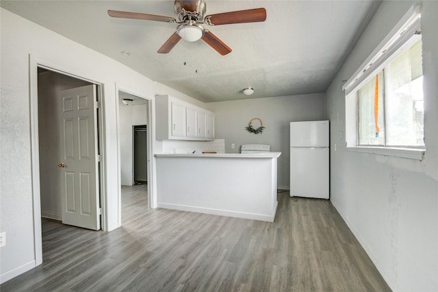 5409 Suez St Unit 4, Houston, TX 77020 - kitchen featuring freestanding refrigerator, light wood-type flooring, a ceiling fan, and white cabinetry