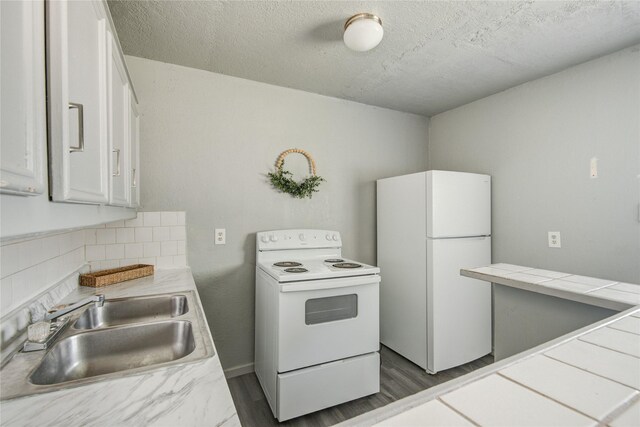 5409 Suez St Unit 4, Houston, TX 77020 - kitchen with a sink, white cabinetry, decorative backsplash, white appliances, and tile countertops