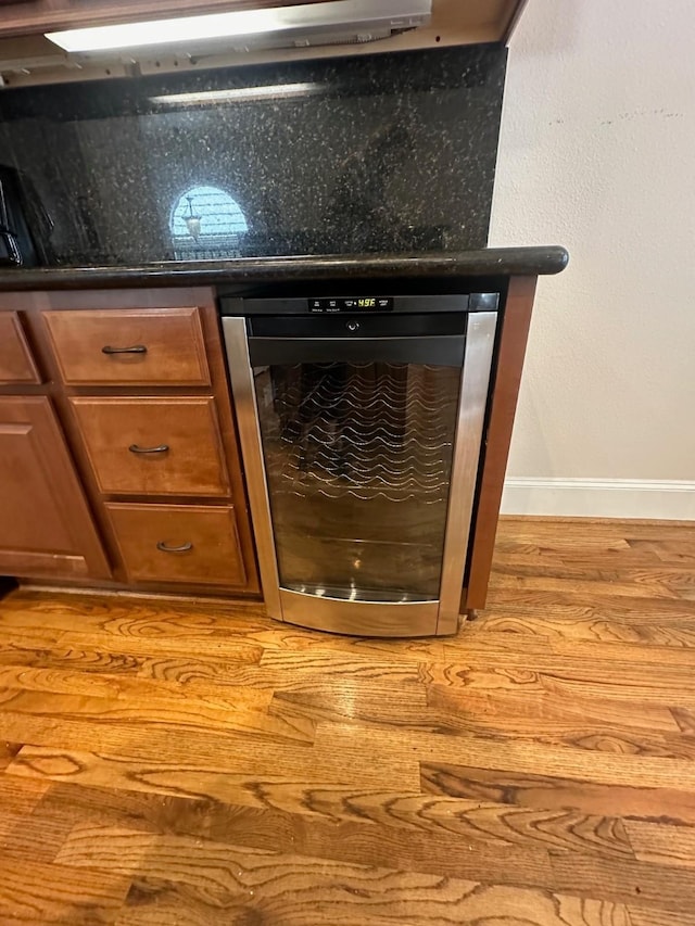 interior details featuring baseboards, wood finished floors, and beverage cooler