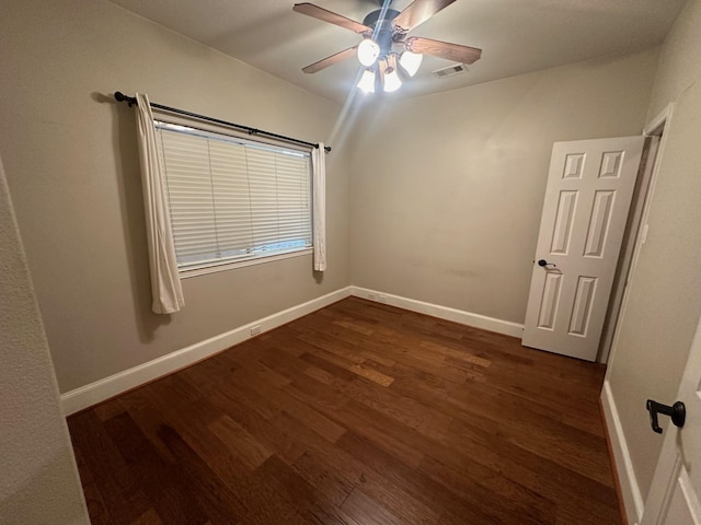 spare room with ceiling fan, baseboards, dark wood-type flooring, and visible vents