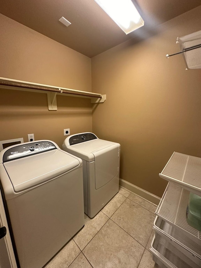 washroom with separate washer and dryer, baseboards, laundry area, and light tile patterned floors