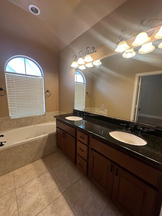 bathroom with tile patterned floors, a sink, double vanity, and a tub with jets