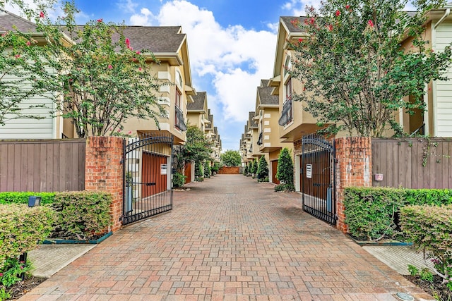 view of road with a gate, a gated entry, and decorative driveway