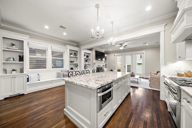 kitchen with a notable chandelier, open shelves, stainless steel appliances, custom range hood, and ornamental molding