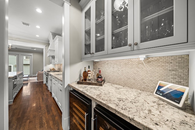 bar featuring dark wood finished floors, wine cooler, ornamental molding, indoor bar, and tasteful backsplash