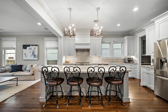 kitchen featuring stainless steel refrigerator with ice dispenser, open floor plan, an inviting chandelier, and a healthy amount of sunlight