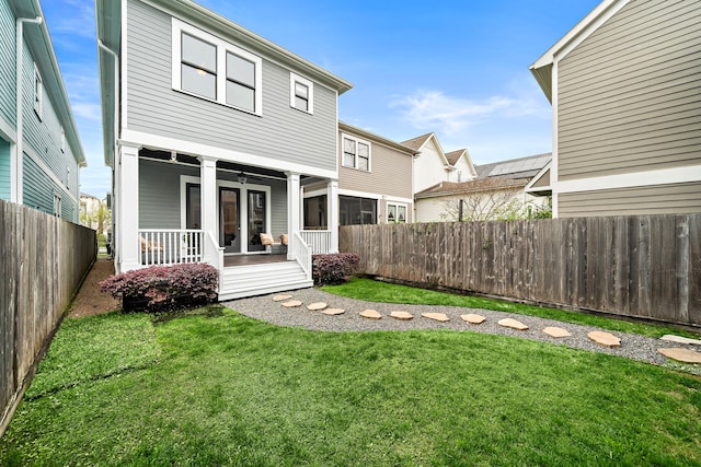 rear view of property featuring a porch, a lawn, a fenced backyard, and ceiling fan