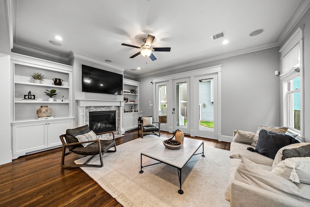 living area with a fireplace with flush hearth, visible vents, dark wood-type flooring, crown molding, and ceiling fan