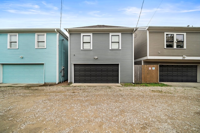 view of front of property with an attached garage and dirt driveway