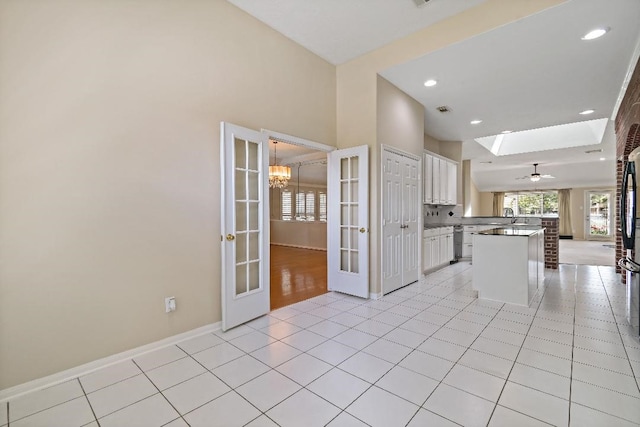 2538 Silent Shore Ct, Richmond, TX 77406 - kitchen featuring white cabinets, baseboards, a chandelier, open floor plan, and light tile patterned floors