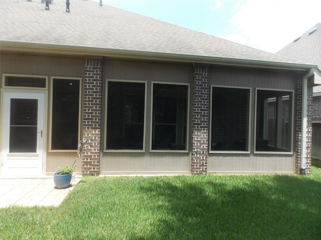 23423 Tavola Rosa Dr, New Caney, TX 77357 - back of house featuring a shingled roof, a lawn, and brick siding