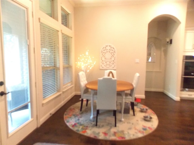 23423 Tavola Rosa Dr, New Caney, TX 77357 - dining area with baseboards, dark wood-style floors, and arched walkways
