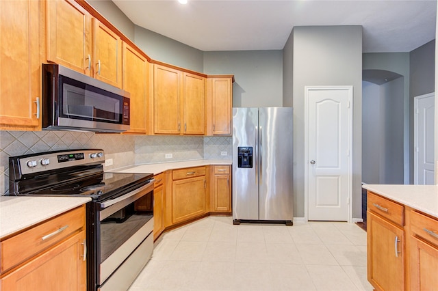 kitchen featuring stainless steel appliances, tasteful backsplash, recessed lighting, light countertops, and light tile patterned floors