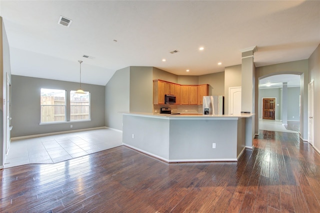 kitchen featuring arched walkways, stainless steel appliances, visible vents, baseboards, and dark wood-style floors