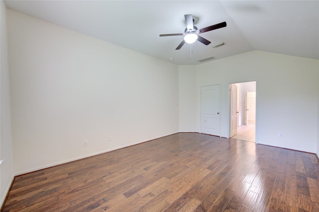 spare room featuring lofted ceiling, visible vents, ceiling fan, and wood finished floors
