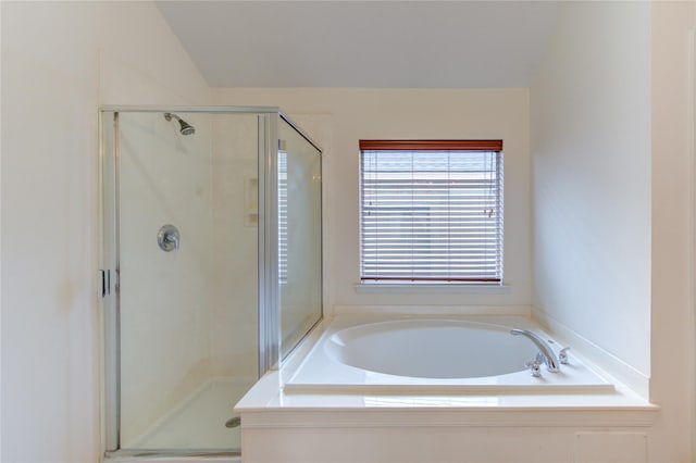 bathroom with a bath, a shower stall, and lofted ceiling