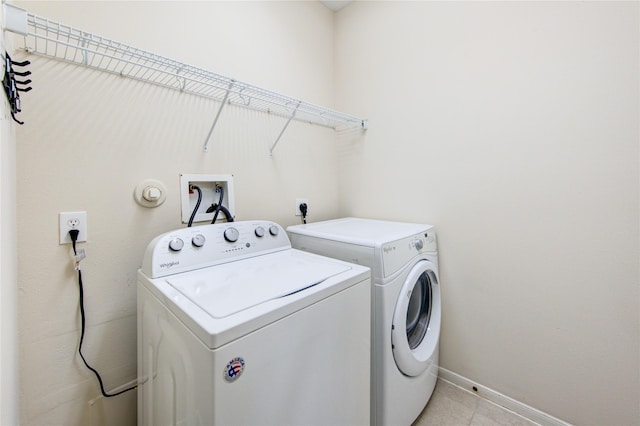 laundry room with washing machine and dryer, baseboards, laundry area, and light tile patterned flooring