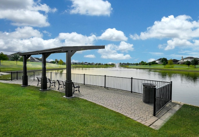 view of dock with a water view and a yard