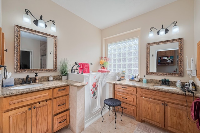 bathroom featuring an enclosed shower, two vanities, and a sink