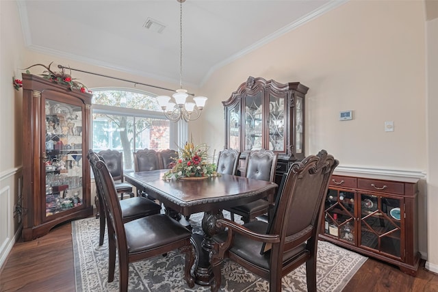dining space featuring visible vents, a notable chandelier, ornamental molding, lofted ceiling, and dark wood-type flooring