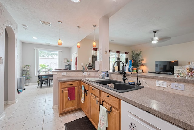 kitchen with ceiling fan, a sink, dishwasher, light tile patterned floors, and visible vents