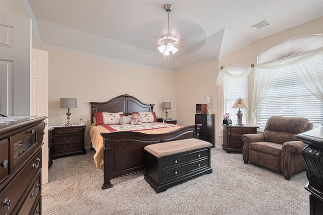 bedroom featuring a raised ceiling, ornamental molding, light carpet, and visible vents