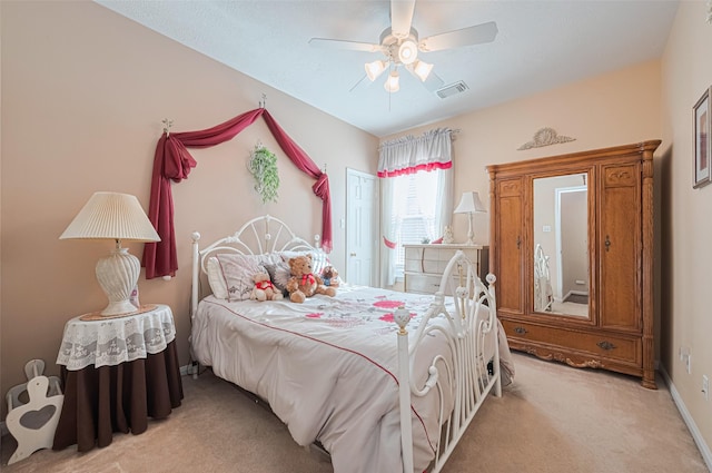 bedroom featuring visible vents, ceiling fan, and light carpet
