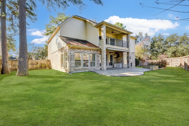 rear view of property featuring a patio area, a balcony, a ceiling fan, a fenced backyard, and a yard