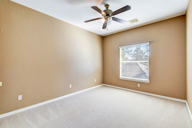 carpeted empty room with ceiling fan, baseboards, and visible vents