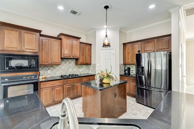 kitchen with tasteful backsplash, visible vents, pendant lighting, a kitchen island, and black appliances