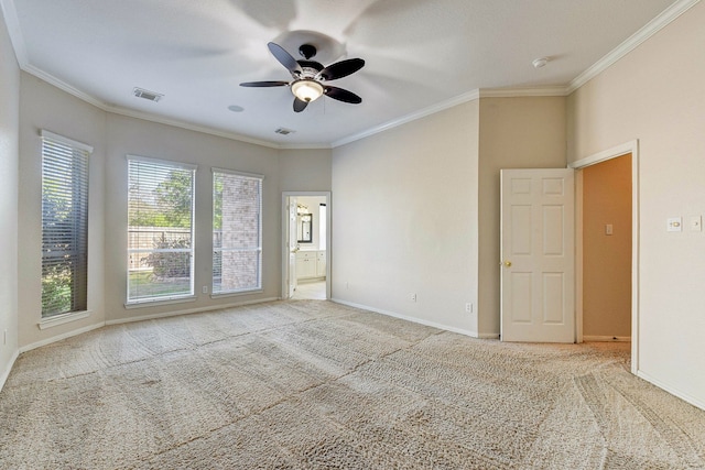 empty room featuring crown molding, carpet, a ceiling fan, and baseboards