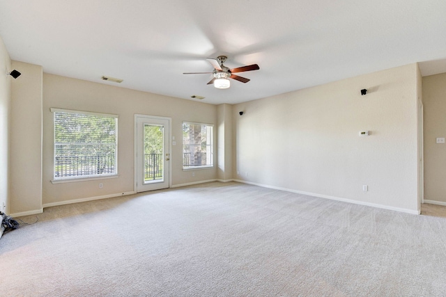 unfurnished room featuring a ceiling fan, visible vents, a wealth of natural light, and carpet floors
