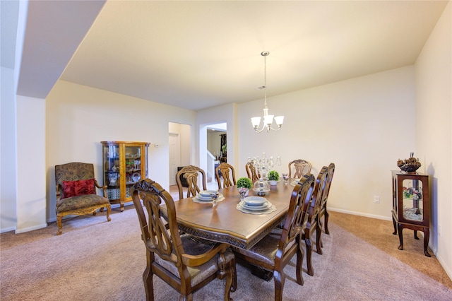 carpeted dining area featuring baseboards and a notable chandelier