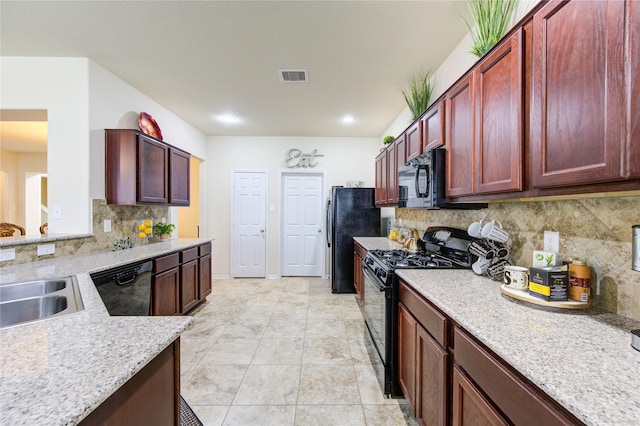 kitchen with dark brown cabinets, visible vents, a sink, black appliances, and tasteful backsplash