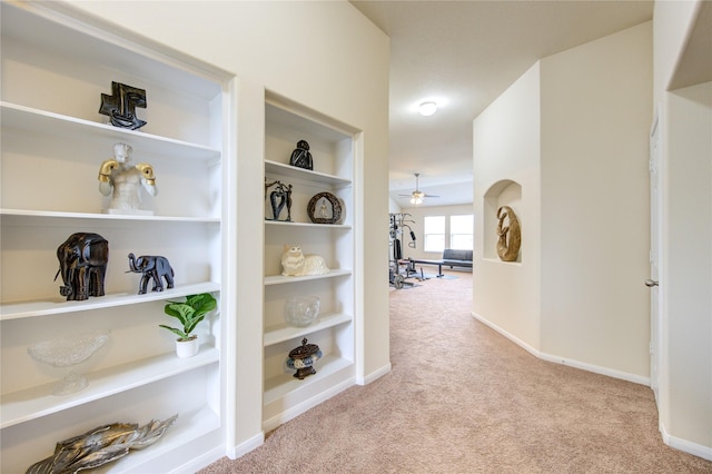 hall with carpet floors, built in features, and baseboards