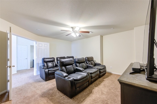cinema room with a ceiling fan, baseboards, and light carpet